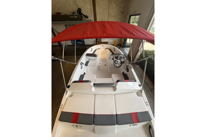 Slide: The Image of 2026 Tahoe T16 boat with red canopy, white and gray seating, and modern steering console. - 4