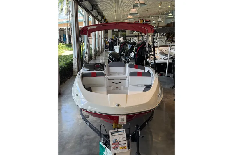 The Image of 2026 Tahoe T16 boat displayed in a showroom, featuring a sleek design and red accents. - 0