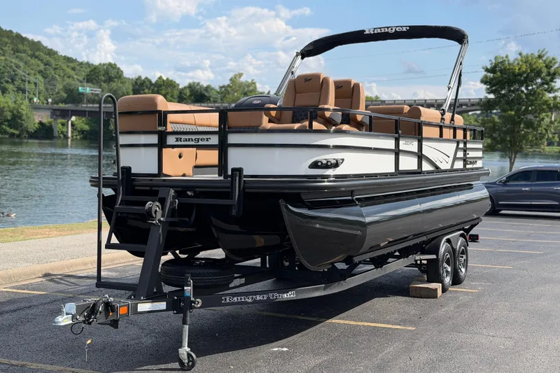Slide: The Image of 2026 Ranger 223FC pontoon boat on trailer by a scenic river. - 10