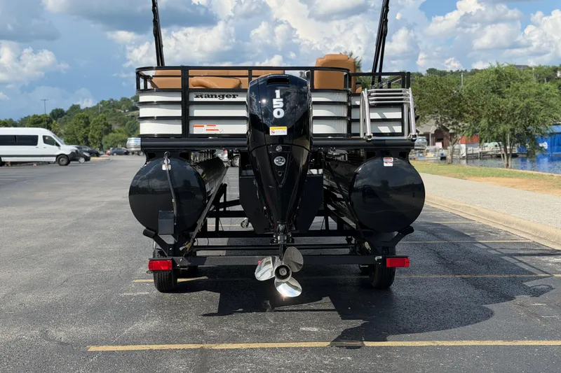 Slide: The Image of 2026 Ranger 223FC boat with powerful outboard motor, parked on asphalt under a cloudy sky. - 2