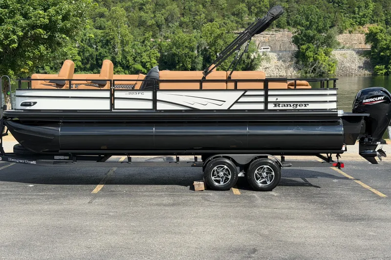 The Image of 2026 Ranger 223FC pontoon boat with Mercury engine, parked near a scenic lake. - 0