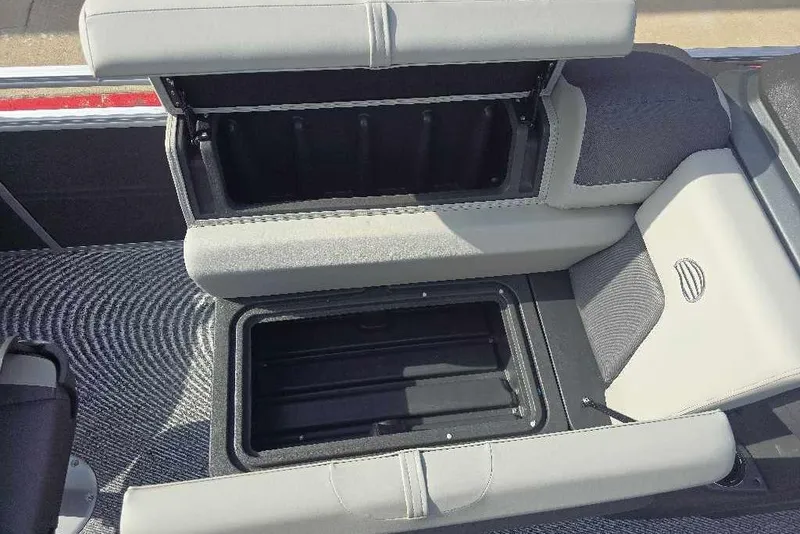 Slide: The Image of 2026 Sun Tracker Fishin' Barge 20 DLX storage compartment with open seat and textured flooring. - 7