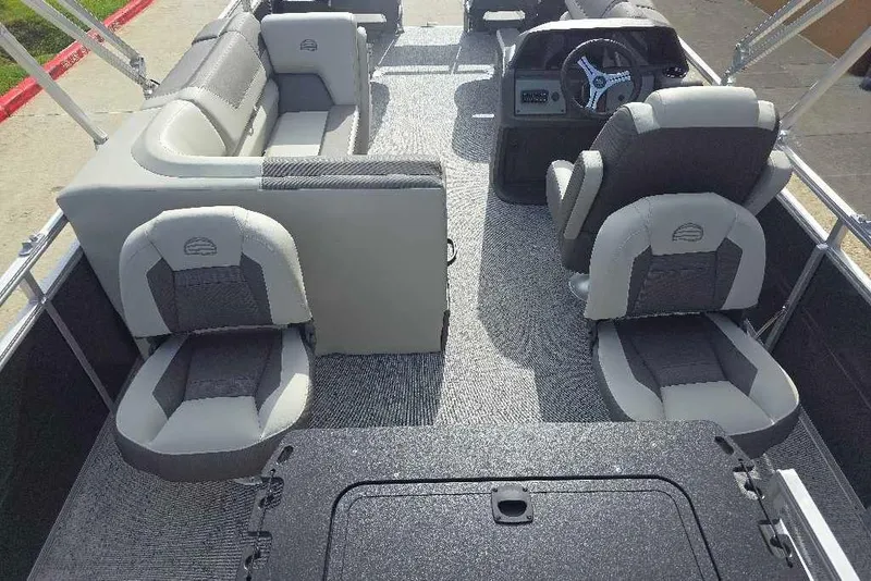 Slide: The Image of 2026 Sun Tracker Fishin' Barge 20 DLX interior with gray seating and steering console. - 18