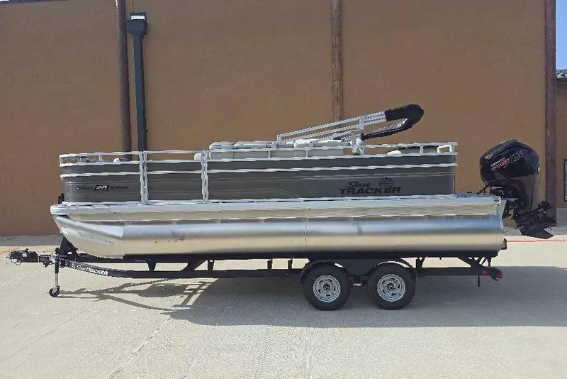 The Image of 2026 Sun Tracker Fishin' Barge 20 DLX pontoon boat on trailer, side view. - 0