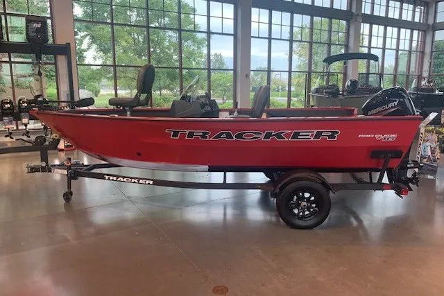 The Image of 2026 Tracker Pro Guide V-16 SC boat in showroom, red exterior, on trailer. - 0