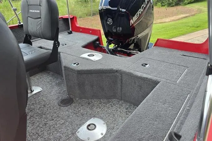 Slide: The Image of 2026 Tracker Pro Guide V-16 WT boat interior with Mercury engine, gray carpet, and seating. - 9