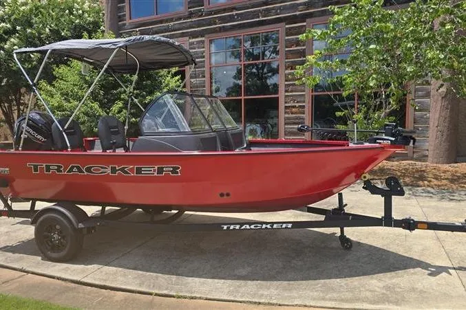 Slide: The Image of 2026 Tracker Pro Guide V-16 WT boat, red, on trailer, parked outdoors. - 2