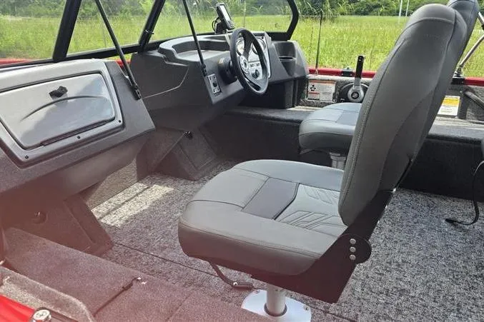 Slide: The Image of Interior of 2026 Tracker Pro Guide V-16 WT boat with gray seating and steering console. - 11