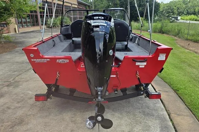 Slide: The Image of 2026 Tracker Pro Guide V-16 WT boat, red exterior, parked on a driveway. - 6