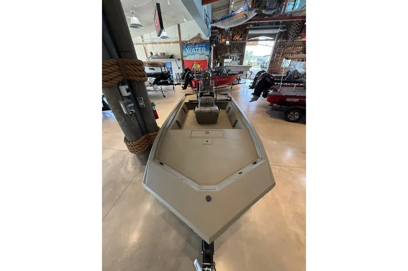 The Image of 2026 Tracker Grizzly 1860 CC boat displayed in a showroom with other boats. - 0