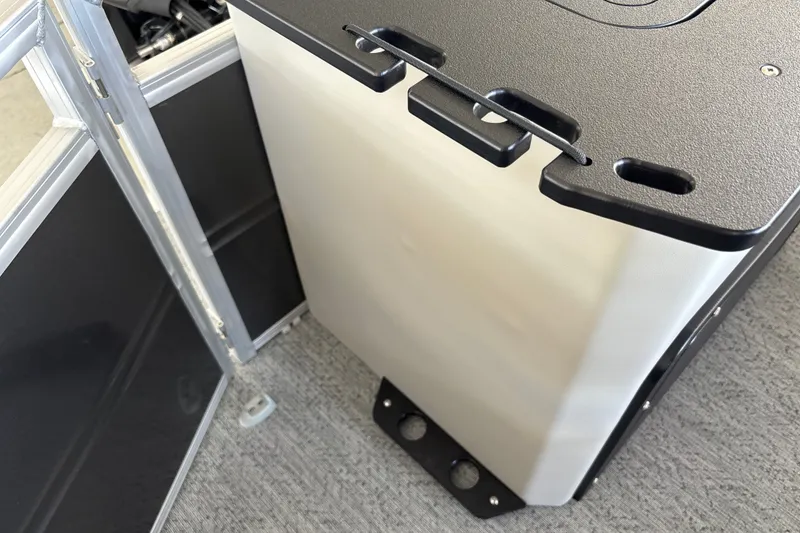 Slide: The Image of 2026 Sun Tracker Fishin' Barge 20 DLX interior detail, featuring storage compartment and seating. - 28
