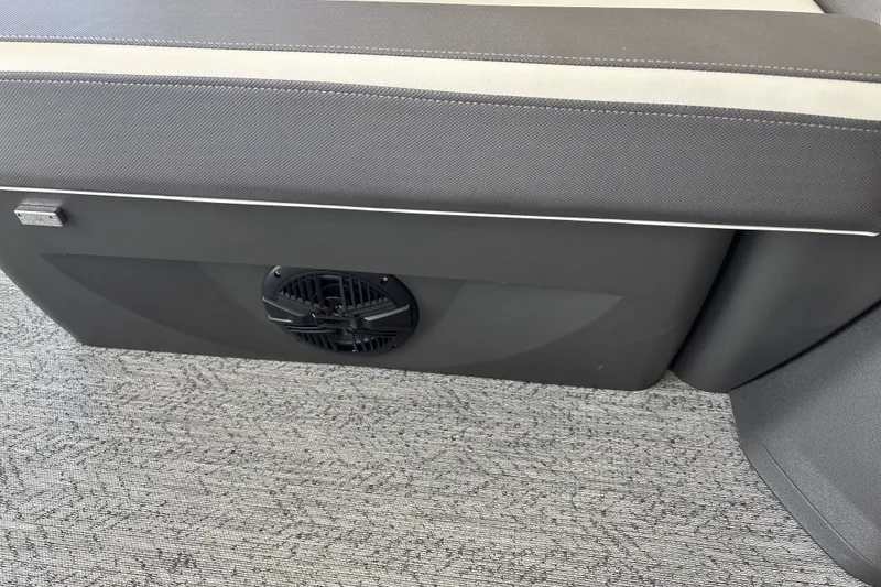 Slide: The Image of 2026 Sun Tracker Fishin' Barge 20 DLX seat with integrated speaker on carpeted floor. - 18