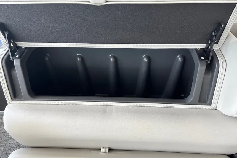 Slide: The Image of 2026 Sun Tracker Fishin' Barge 20 DLX storage compartment with open lid, showcasing interior space. - 38