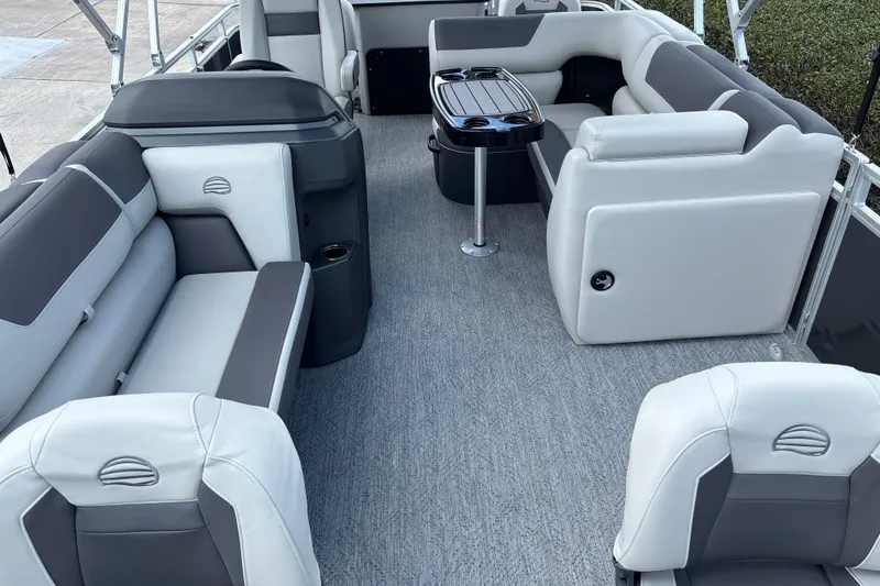 Slide: The Image of 2026 Sun Tracker Fishin' Barge 20 DLX interior with gray seating and table. - 13