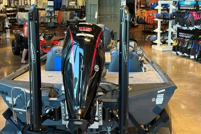 Slide: The Image of 2026 Ranger RT188P boat displayed in a showroom with a powerful outboard motor. - 2