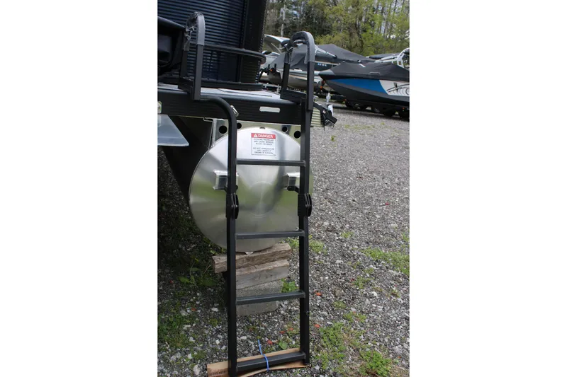 Slide: The Image of Ladder attached to a 2026 Bennington 22 SSRSF pontoon boat, parked on gravel. - 6