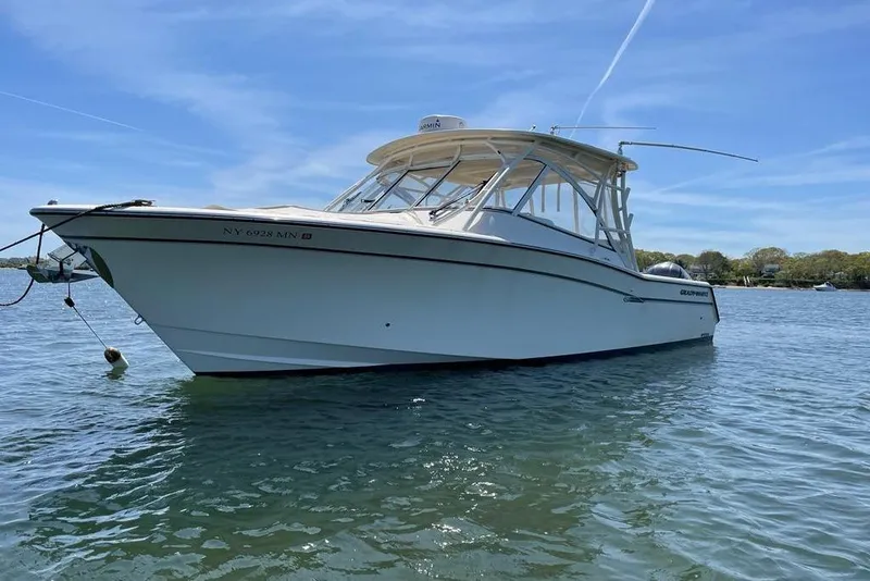 The Image of 2017 Grady White Freedom 335 boat anchored on calm water under clear blue sky. - 0