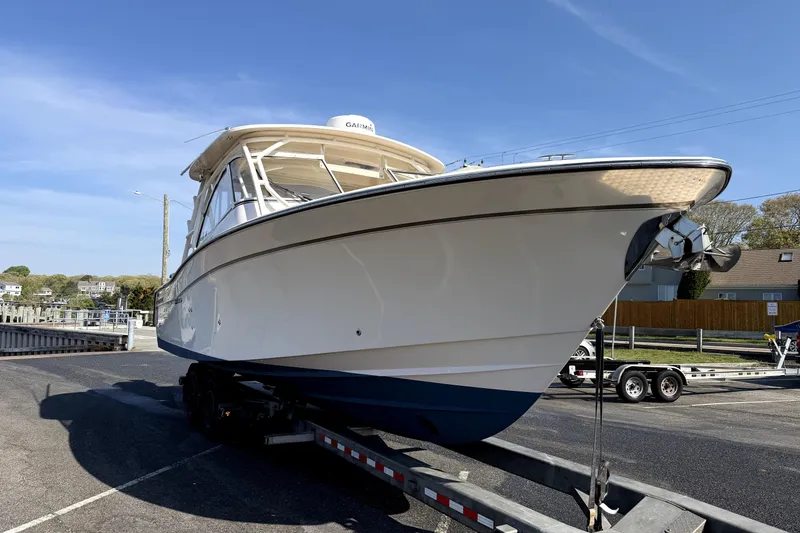 Slide: The Image of 2017 Grady White Freedom 335 boat on trailer, parked outdoors under clear sky. - 4
