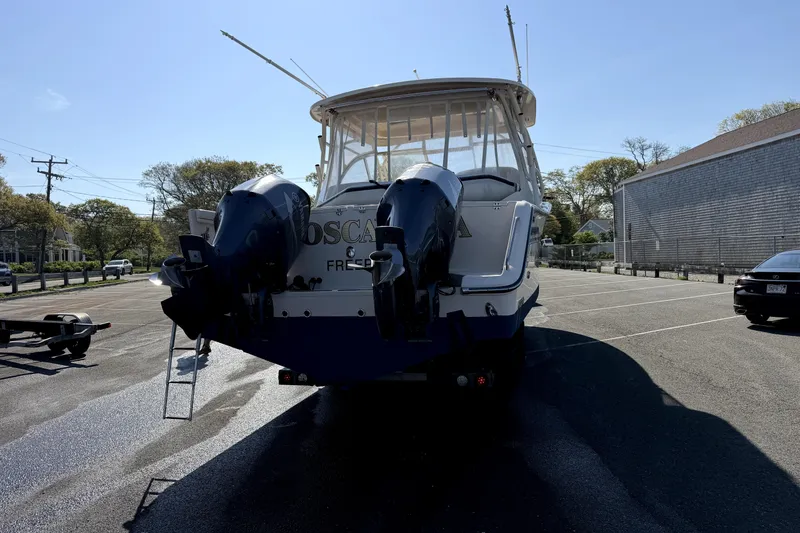 Slide: The Image of 2017 Grady White Freedom 335 boat with dual engines in a parking lot. - 5