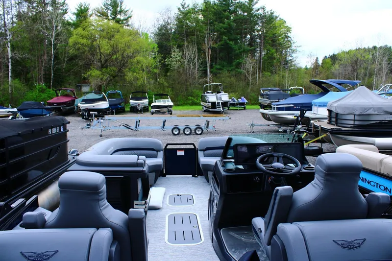 Slide: The Image of 2026 Bennington 24 MFBSF pontoon boat interior with parked boats in background. - 8