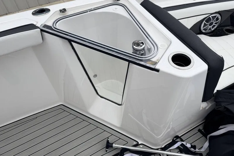 Slide: The Image of 2023 Yamaha Boats 255 FSH Sport E interior detail with seating and storage compartment. - 12