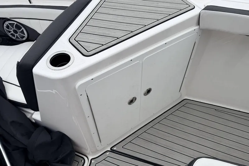 Slide: The Image of 2023 Yamaha Boats 255 FSH Sport E interior with sleek seating and storage compartments. - 13