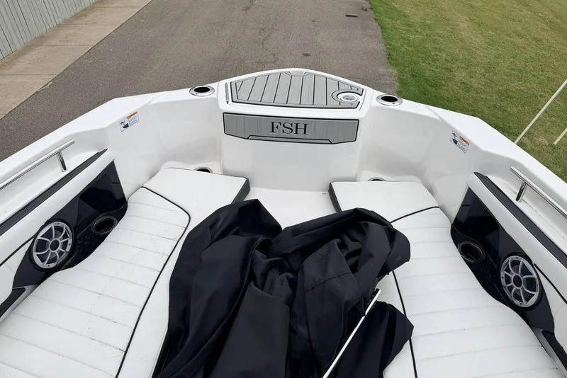 Slide: The Image of 2023 Yamaha Boats 255 FSH Sport E interior with white seating and speakers. - 14