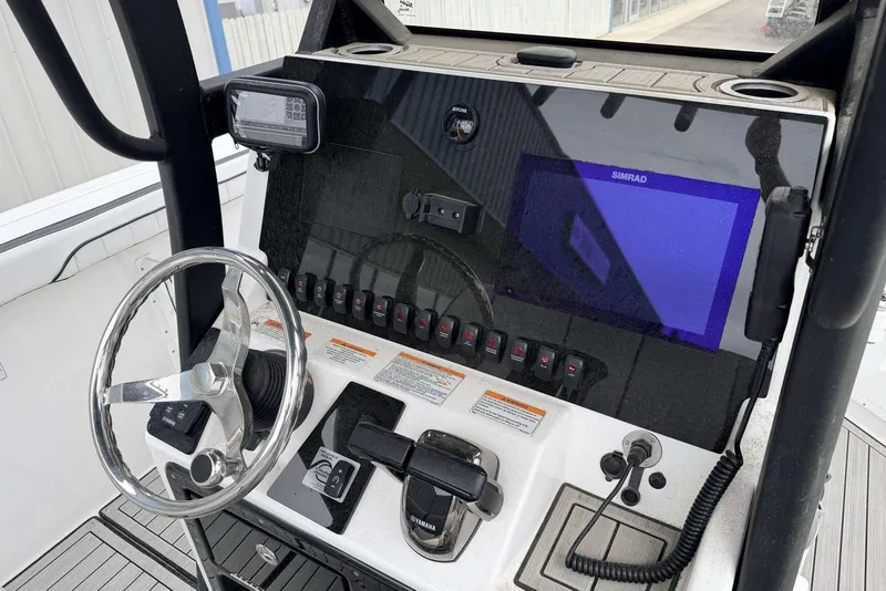 Slide: The Image of 2023 Yamaha Boats 255 FSH Sport E dashboard with steering wheel and navigation controls. - 15