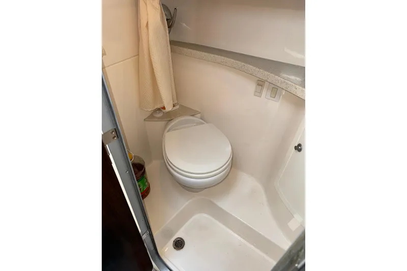 Slide: The Image of Bathroom interior of 2017 Regal 28 Express boat, featuring a compact toilet and shower area. - 11