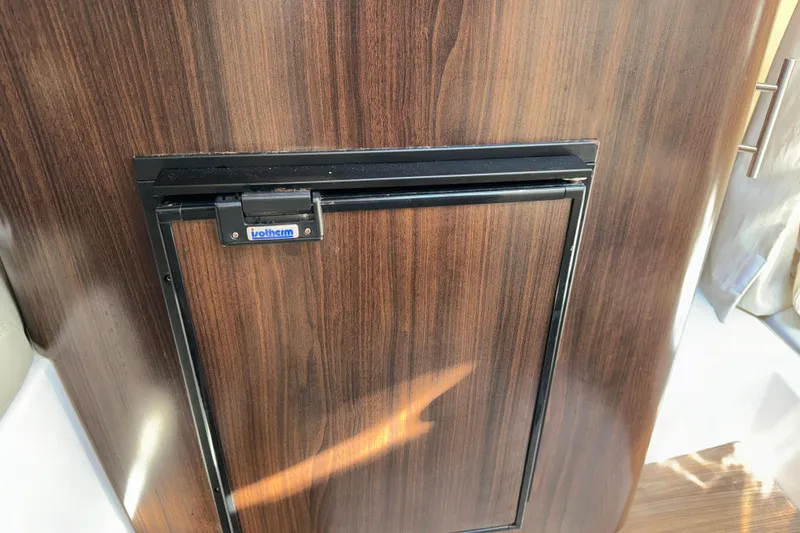 Slide: The Image of Wood-paneled mini fridge in 2017 Regal 28 Express boat interior. - 12
