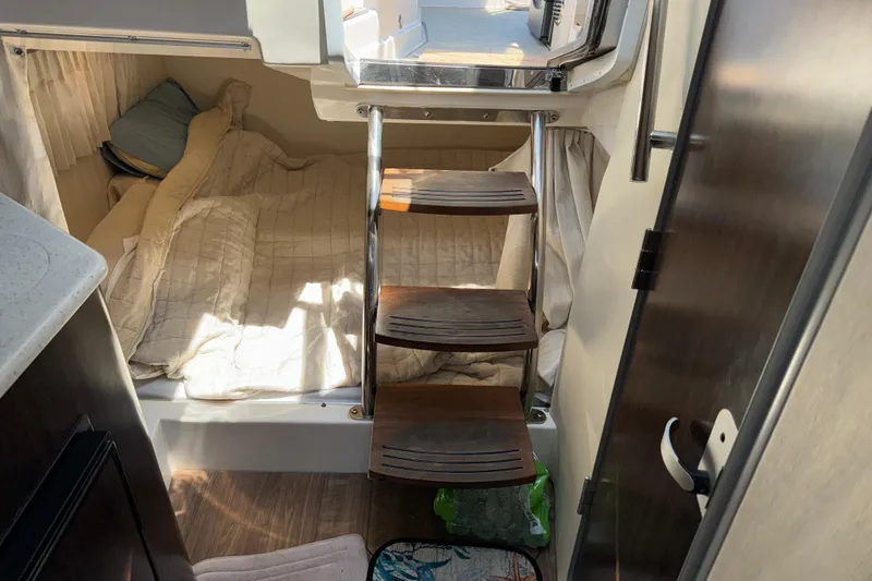 Slide: The Image of 2017 Regal 28 Express cabin interior with bed and wooden steps. - 15