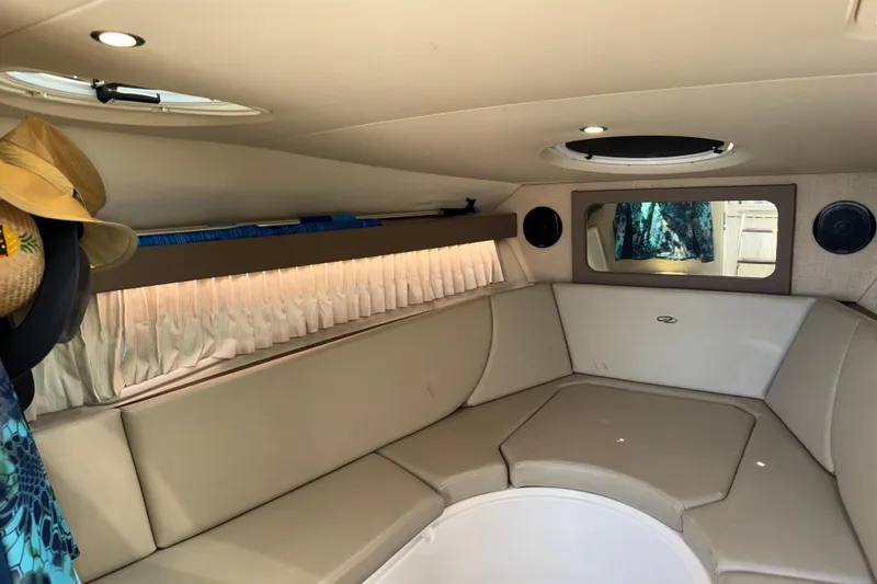 Slide: The Image of Interior of a 2017 Regal 28 Express boat with beige seating and circular windows. - 2