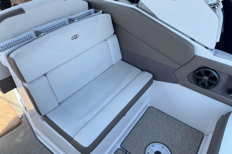 Slide: The Image of Interior seating of a 2017 Regal 28 Express boat, featuring cushioned seats and speaker. - 21