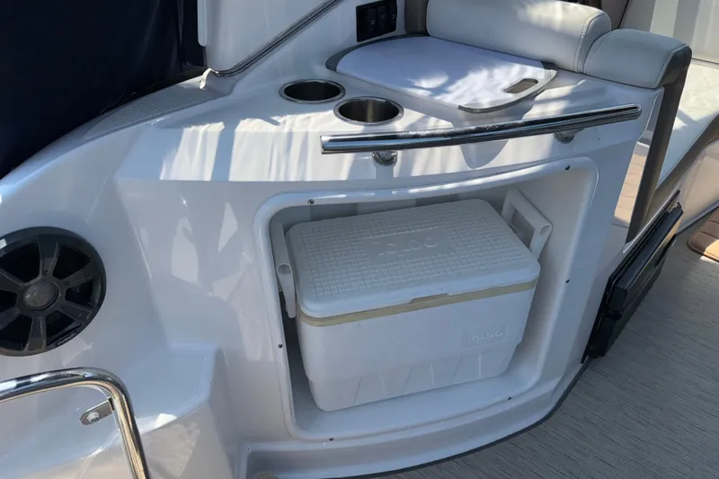 Slide: The Image of 2017 Regal 28 Express boat interior with cooler and cup holders. - 23