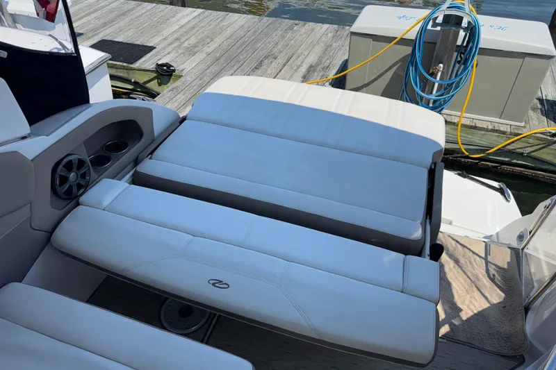 Slide: The Image of 2017 Regal 28 Express boat interior with white cushioned seating and cup holders. - 26