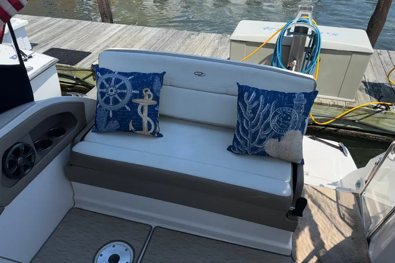 Slide: The Image of Cozy seating area on a 2017 Regal 28 Express boat with nautical-themed pillows. - 3