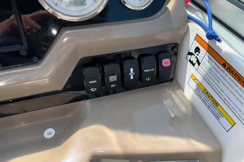 Slide: The Image of Control panel of a 2017 Regal 28 Express boat with switches and warning labels. - 36