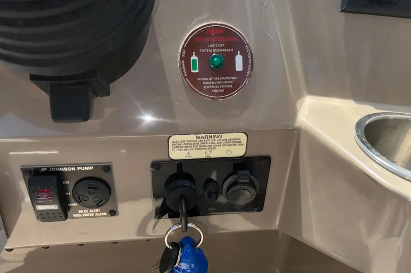 Slide: The Image of Control panel of a 2017 Regal 28 Express boat with warning labels and ignition keys. - 38