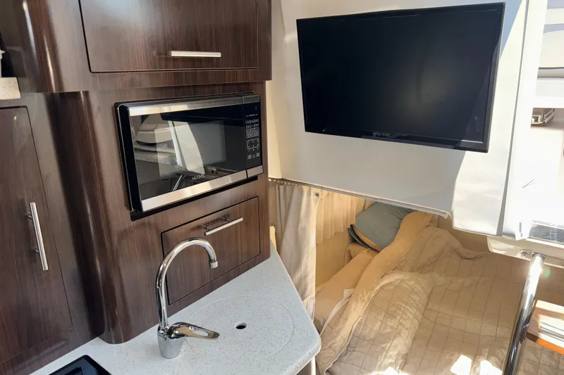 Slide: The Image of Interior of 2017 Regal 28 Express boat with kitchenette, microwave, and TV. - 4