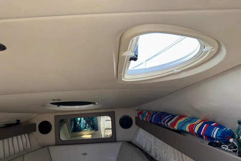 Slide: The Image of Interior cabin of a 2017 Regal 28 Express boat with porthole and colorful cushion. - 49
