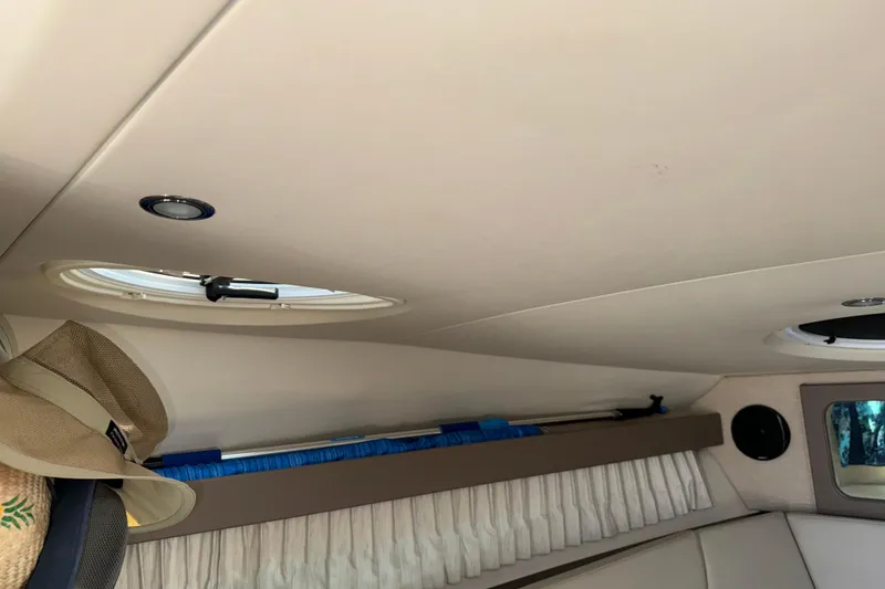 Slide: The Image of Interior cabin of a 2017 Regal 28 Express boat with porthole and hat. - 50