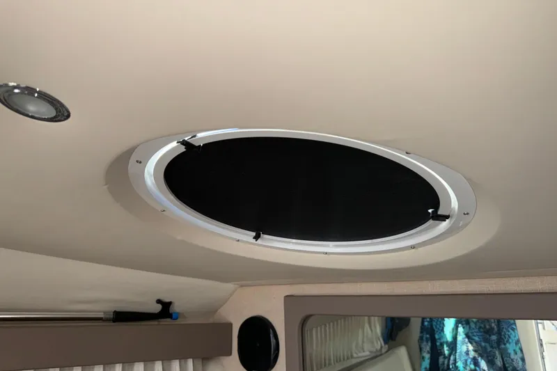 Slide: The Image of Ceiling hatch inside 2017 Regal 28 Express boat cabin, featuring a circular design. - 51