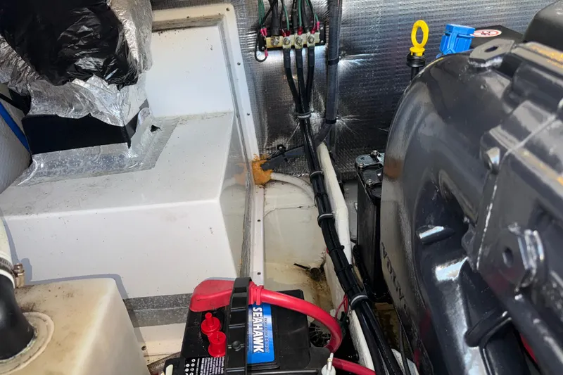 Slide: The Image of Engine compartment of a 2017 Regal 28 Express boat, featuring wiring and battery setup. - 59