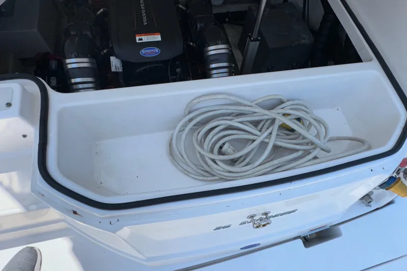 Slide: The Image of Open engine compartment of 2017 Regal 28 Express boat with coiled rope inside. - 63