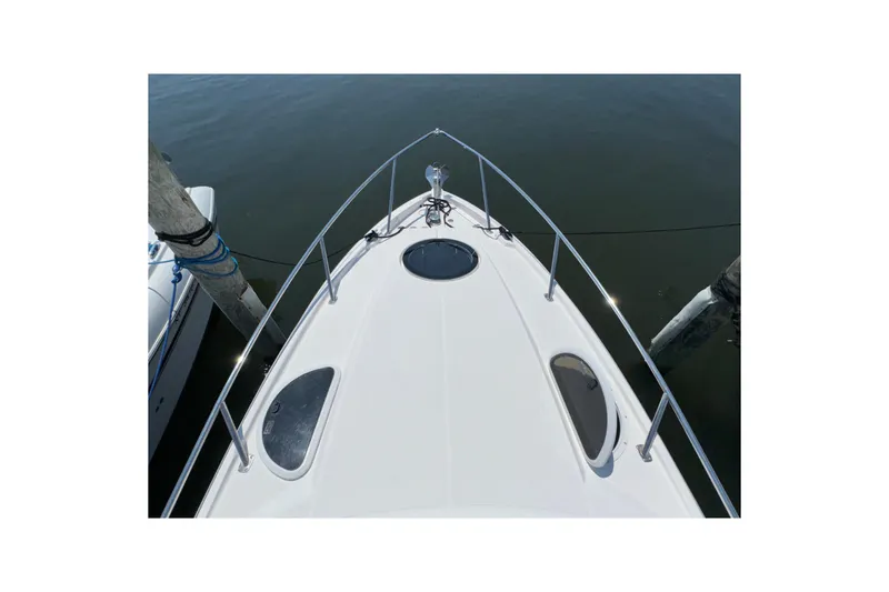 Slide: The Image of Bow view of 2017 Regal 28 Express boat docked on calm water. - 66