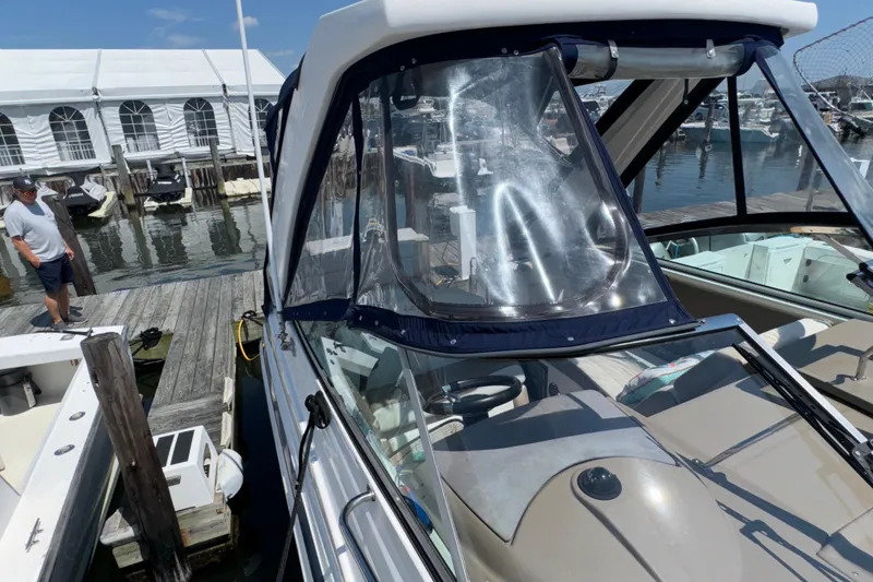 Slide: The Image of 2017 Regal 28 Express boat docked at marina with clear canopy. - 69