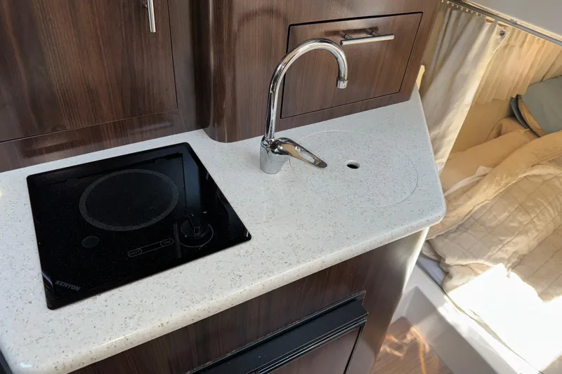 Slide: The Image of Compact kitchen area in 2017 Regal 28 Express boat with stove and sink. - 7