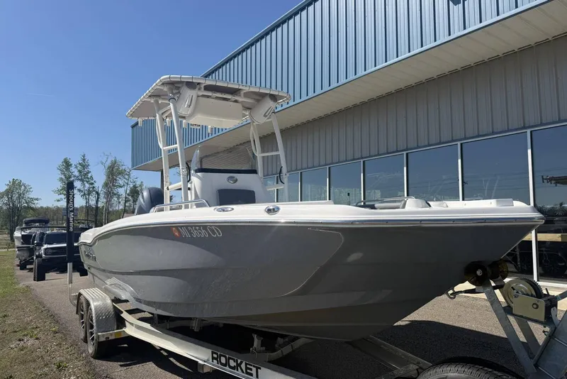 The Image of 2023 NauticStar 211 Hybrid boat on trailer outside a building. - 0