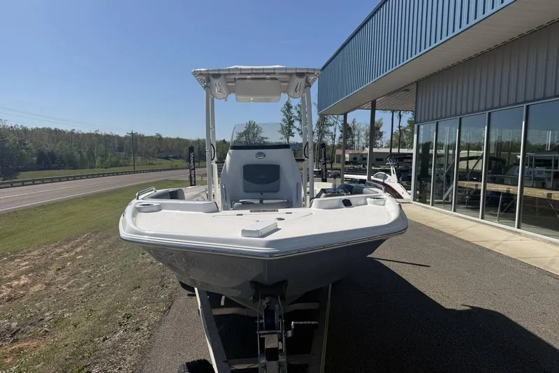Slide: The Image of 2023 NauticStar 211 Hybrid boat displayed outdoors near a showroom. - 1