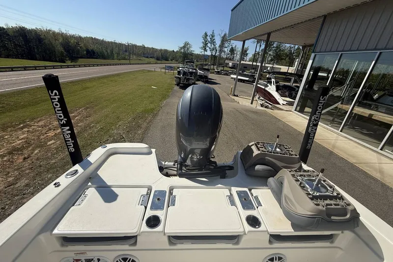 Slide: The Image of 2023 NauticStar 211 Hybrid boat at Shoup's Marine dealership, showcasing rear deck and motor. - 2